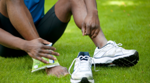 A man sitting on the ground suffering from ankle fracture